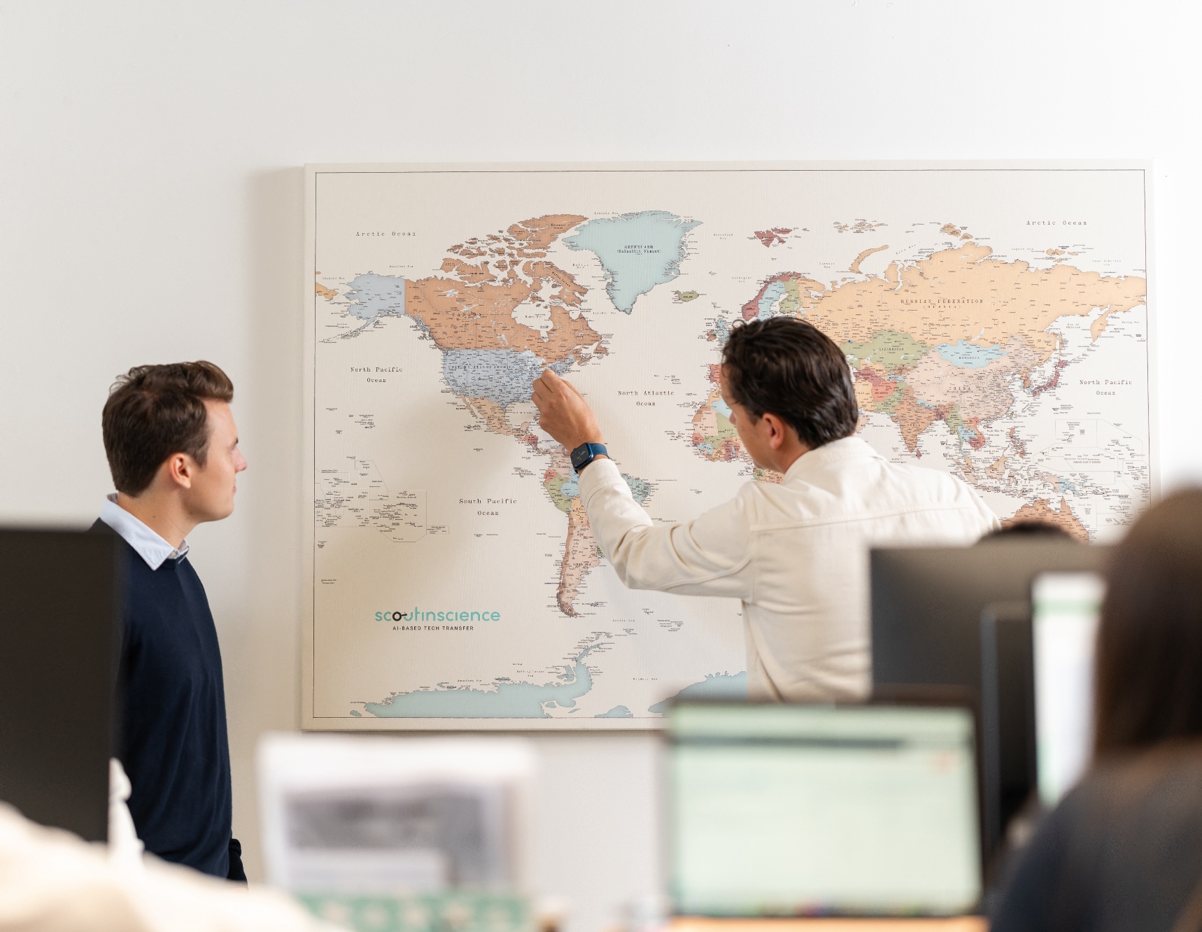 An image of a man putting another pin on a world map.